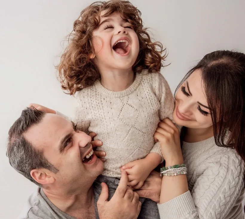A mum and her family laughing together during their Verve portrait session